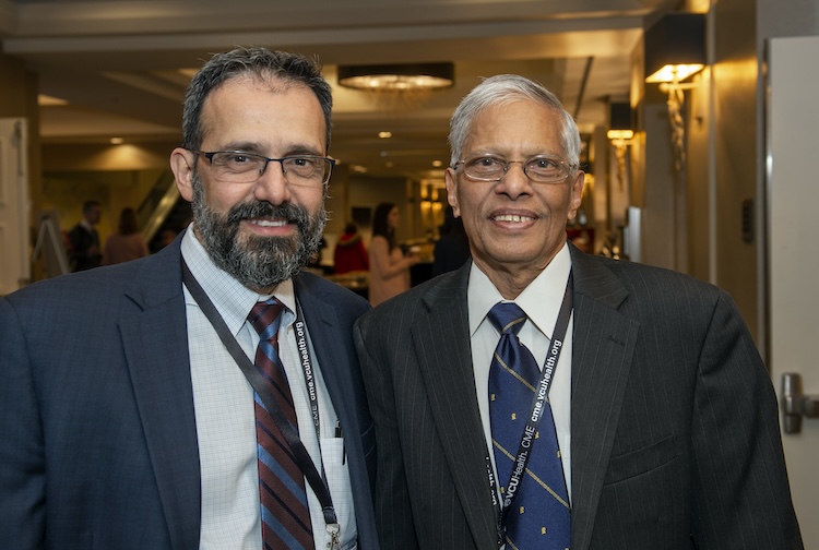 Two men in suits smiling