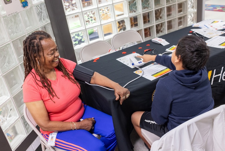 Woman gets her blood pressure taken by a student