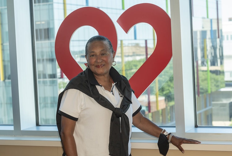 Woman standing in front of a heart logo