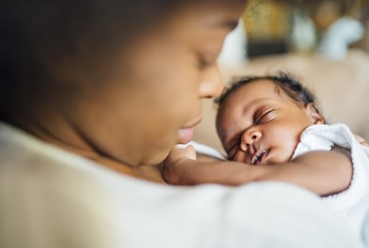  Mom snuggling newborn