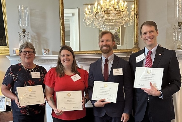 Group of people standing next to each other holding certificates 
