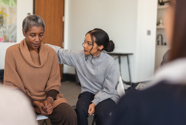 Young woman shows support to an older woman in therapy session