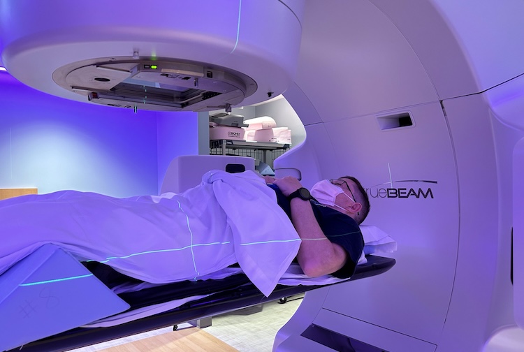 Greg lays in a machine is scanning him