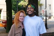 Couple stands together smiling outside of a hospital building.