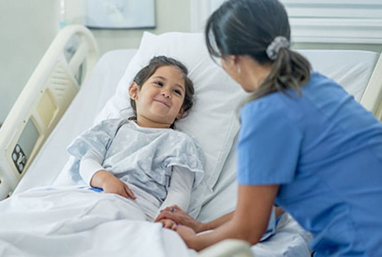 child patient looking at nurse and smiling