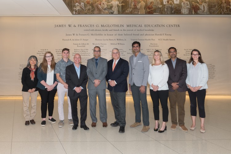 Group of people in business attire stand together for a photo
