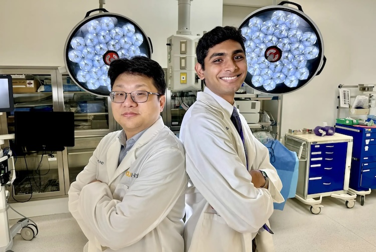 Two men in lab coast smiling in an operating room