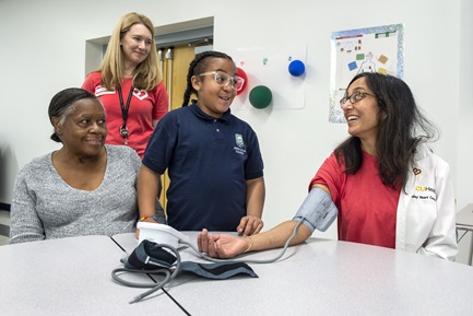 Child taking blood pressure of doctor