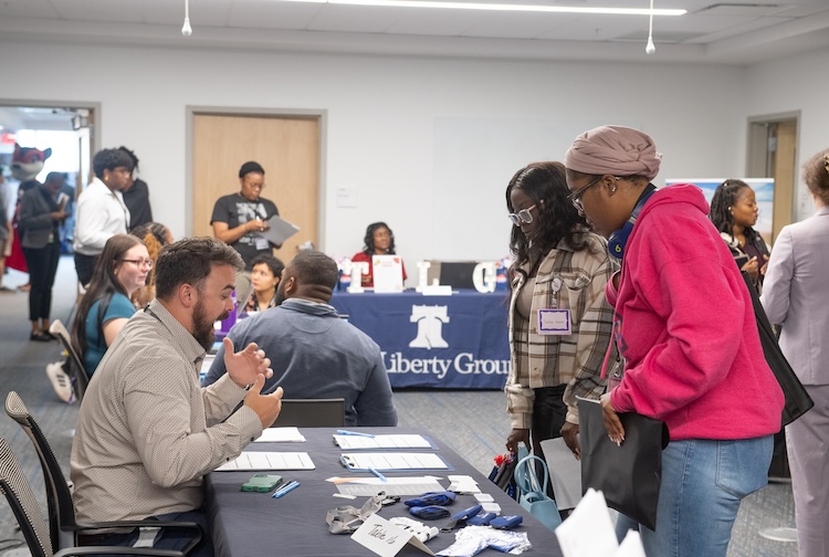 People speaking to vendors at tables