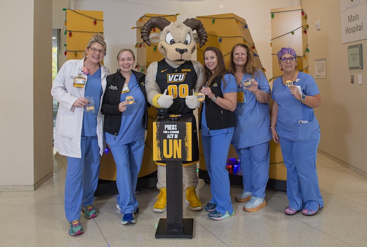 Rodney the ram standing with several nurses holding up cookies