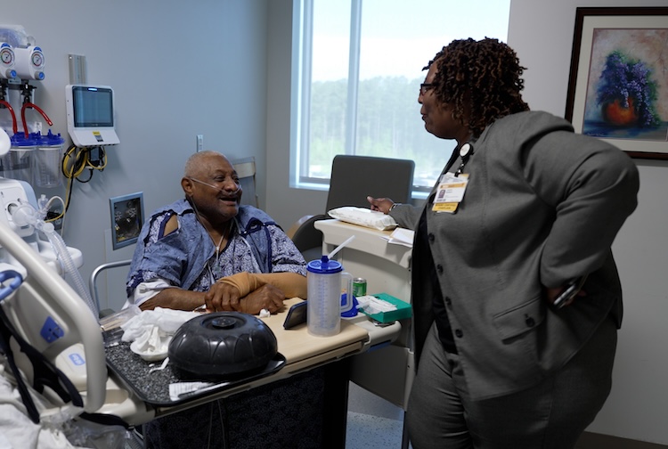 Woman speaks with patient both are smiling