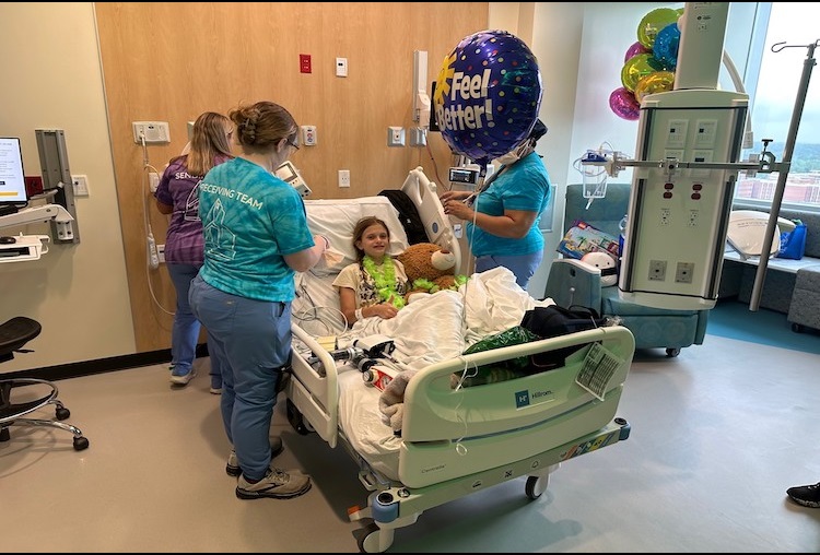 Patient smiles for picture while moving into Children's Tower. 