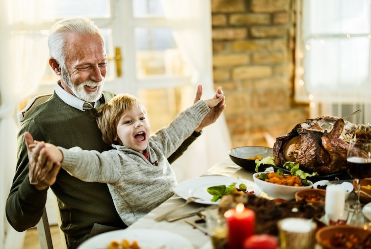 Happy grandfather and grandson having fun during a Thanksgiving lunch at home