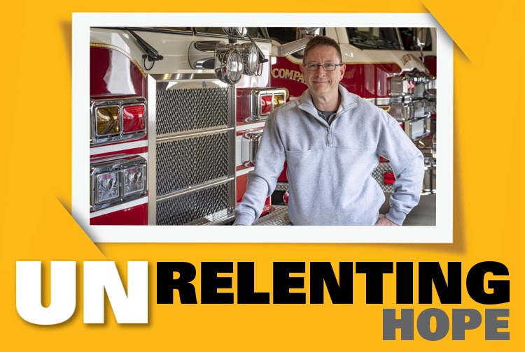 Greg Leitz next to a fire truck with the words unrelenting hope next to him