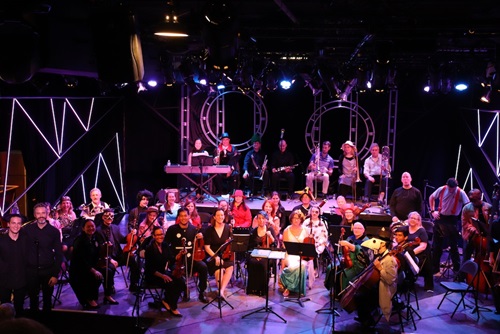 Orchestra smiles with instruments.