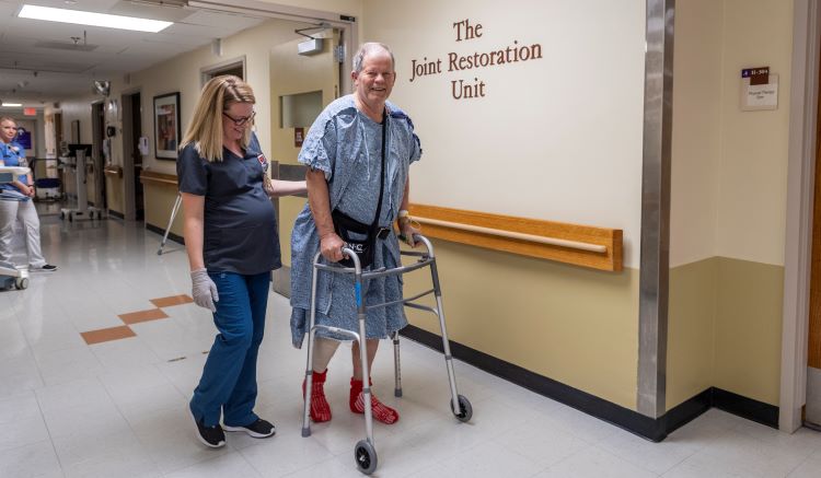 Healthcare provider and patient walking down hallway